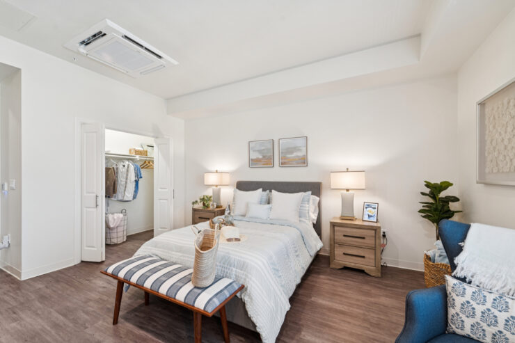 A serene bedroom with elegant decor, inviting comfort and a sense of community awaits residents.