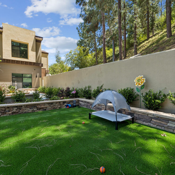 A serene outdoor space invites relaxation, featuring lush greenery and a charming tent for comfort.