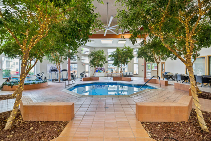 A welcoming indoor pool area surrounded by lush greenery, promoting relaxation and community spirit.
