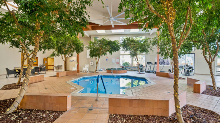 A serene indoor pool area surrounded by lush greenery, promoting relaxation and community bonding.