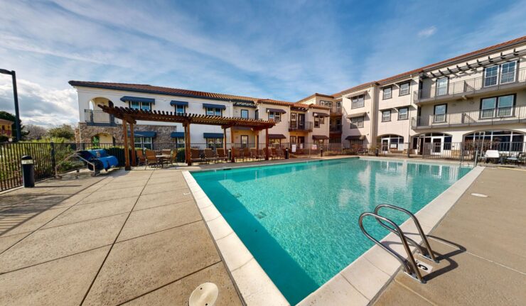 A serene pool area invites relaxation and connection, surrounded by welcoming community spaces.