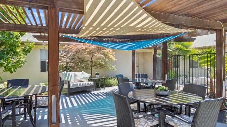 Shaded outdoor seating invites relaxation and connection in a vibrant, welcoming community space.