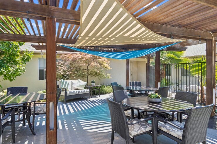 Shaded outdoor seating invites relaxation and connection in a vibrant, welcoming community space.