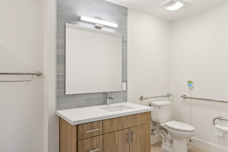 A bright, welcoming bathroom featuring modern fixtures and warm wood accents, promoting comfort and safety.