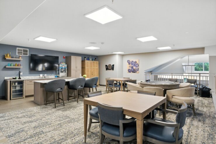 A welcoming lounge area features comfortable seating, a spacious kitchen, and vibrant decor, fostering community.