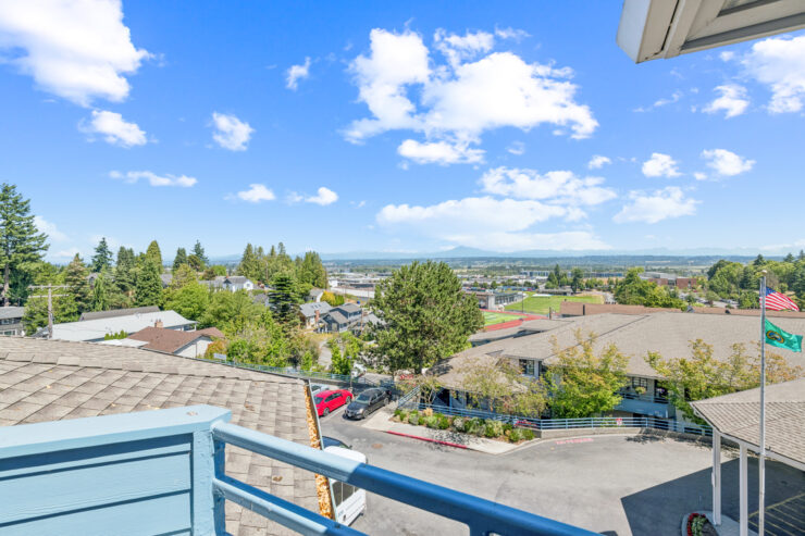 A serene view showcasing a vibrant community, surrounded by lush greenery and a clear blue sky.