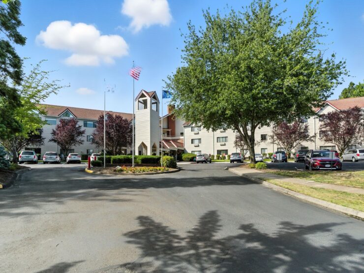 A welcoming retirement community surrounded by lush greenery, fostering connection and comfort.