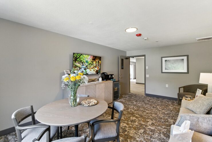 A welcoming common area with vibrant flowers, inviting seating, and a warm, friendly atmosphere.