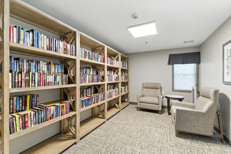 A bright, inviting library space featuring comfortable seating and ample bookshelves, fostering community and relaxation.