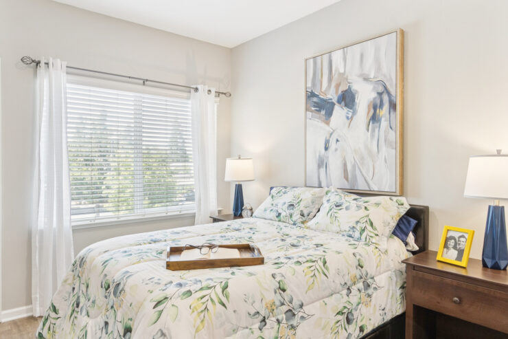 A bright, welcoming bedroom featuring floral decor, natural light, and a serene atmosphere for relaxation.