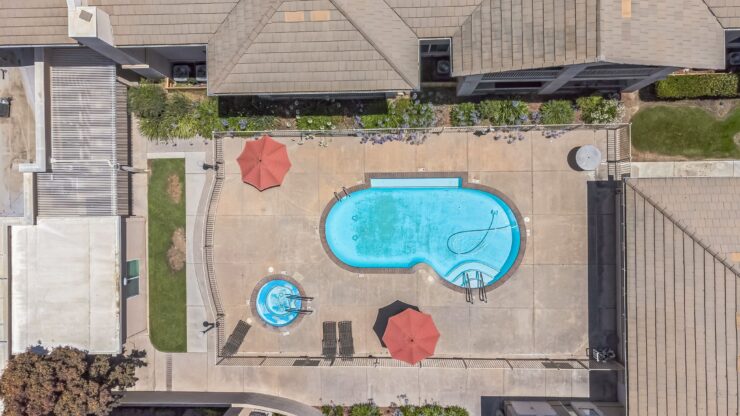 A vibrant pool area with lounge chairs and umbrellas, inviting relaxation and community gatherings.