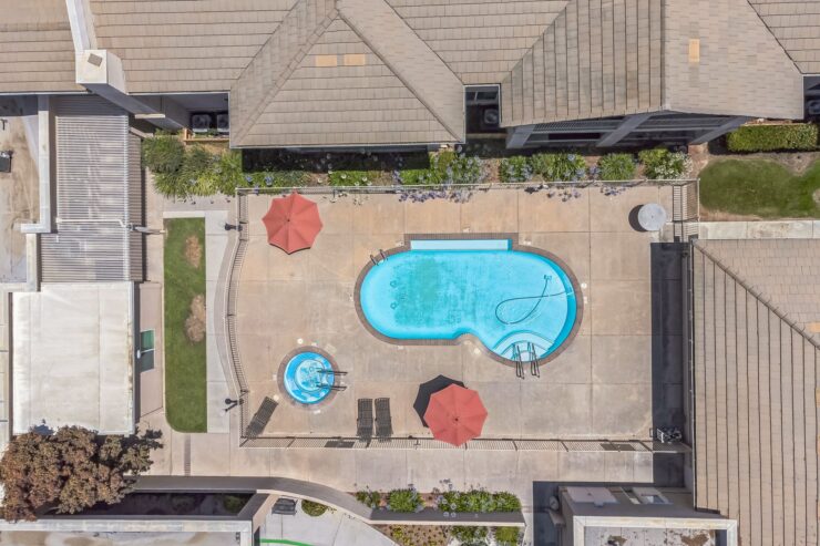 A vibrant pool area with lounge chairs and umbrellas, inviting relaxation and community gatherings.