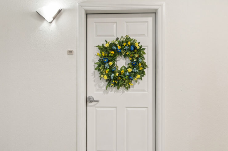 A welcoming door adorned with a vibrant wreath, inviting warmth and a sense of community.