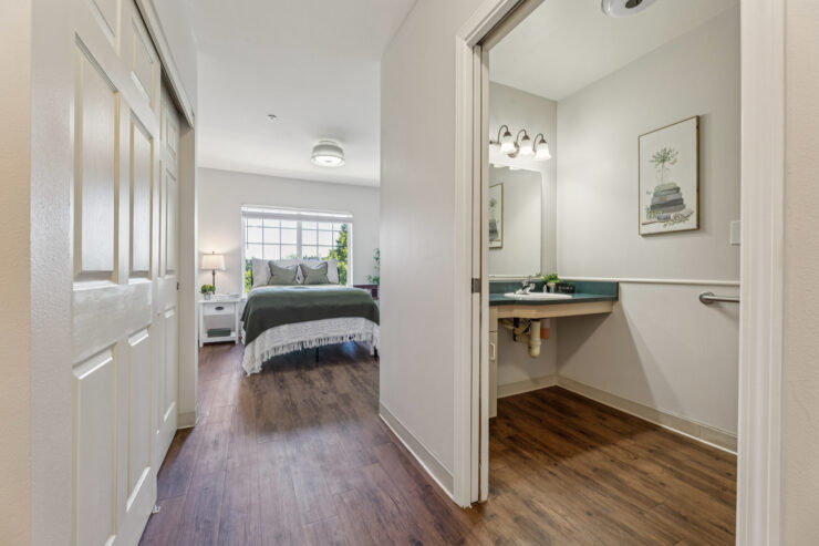 A welcoming room with natural light, featuring a comfortable bed and a clean, bright bathroom.