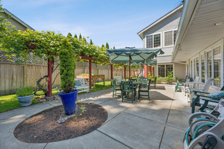 A welcoming outdoor space with shaded seating, lush greenery, and a serene atmosphere invites community gatherings.