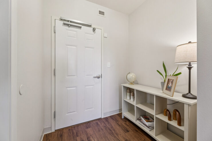 A welcoming entryway with warm wooden floors and personal touches fosters a sense of community and comfort.