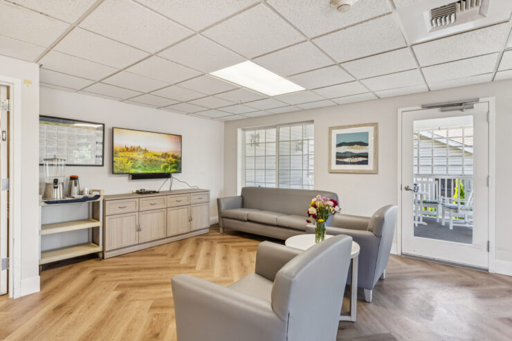 A welcoming lounge area with comfortable seating, natural light, and vibrant artwork fosters community and relaxation.