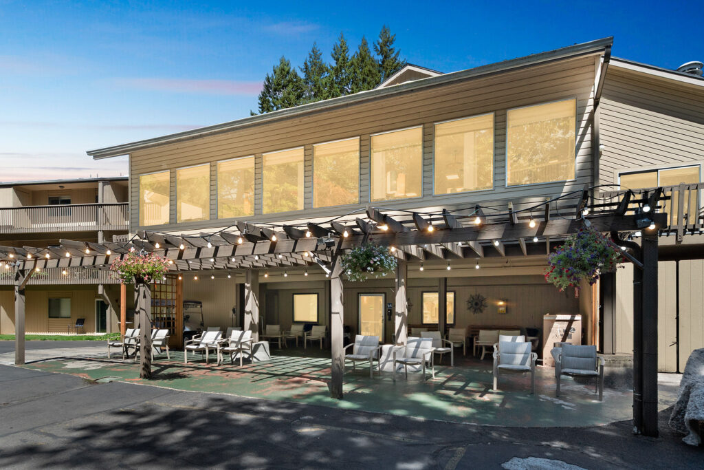 A welcoming outdoor space with comfortable seating, surrounded by nature, perfect for community gatherings.