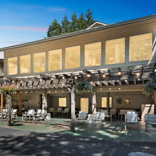 A welcoming outdoor space with comfortable seating, surrounded by nature, perfect for community gatherings.