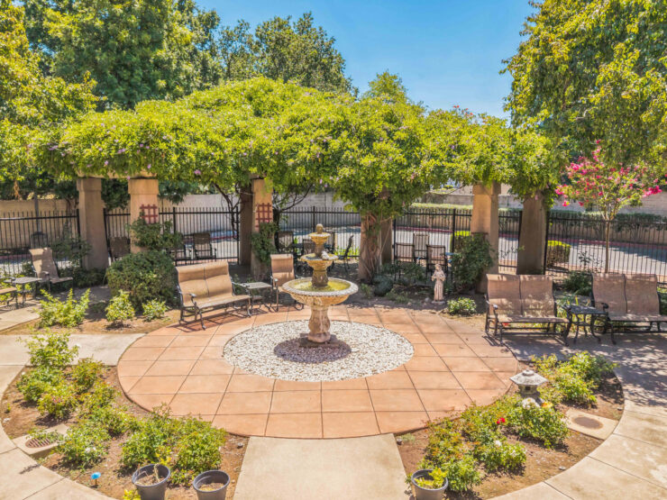 A serene garden retreat with a fountain, inviting seating, and lush greenery, perfect for community gatherings.