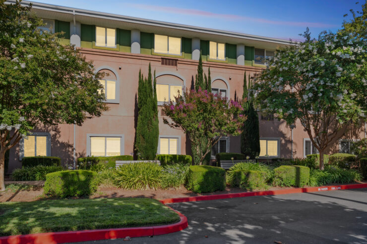 A welcoming retirement community, surrounded by lush greenery and a serene atmosphere, perfect for relaxation.