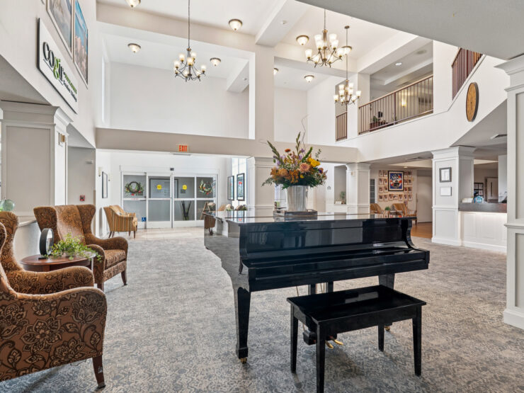 A welcoming lobby features elegant decor, a grand piano, and comfortable seating, fostering community and warmth.