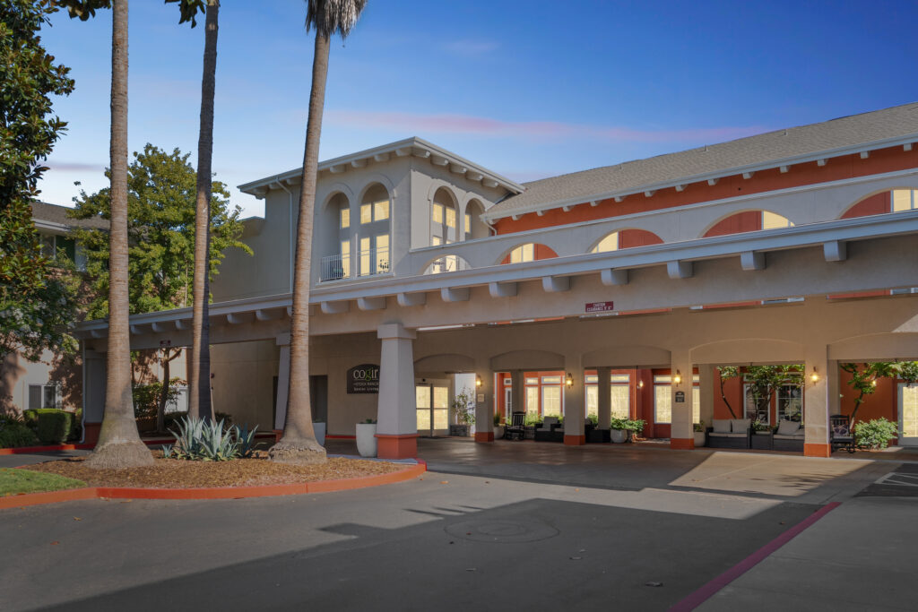 A welcoming entrance surrounded by palm trees, inviting residents to a vibrant community.