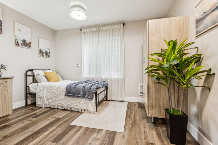 A serene bedroom with natural light, inviting decor, and a touch of greenery, fostering a sense of home.