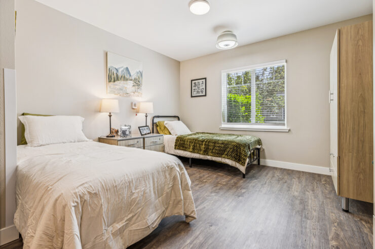 Bright, inviting bedroom designed for comfort, featuring twin beds and cheerful natural light.