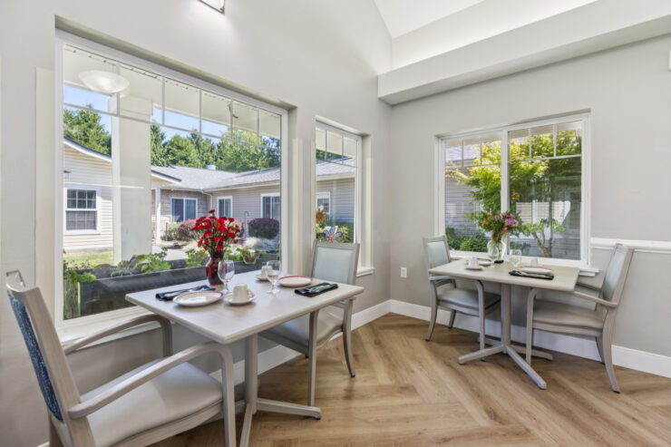 Bright dining area with cheerful flowers, inviting natural light, and a welcoming atmosphere for community gatherings.