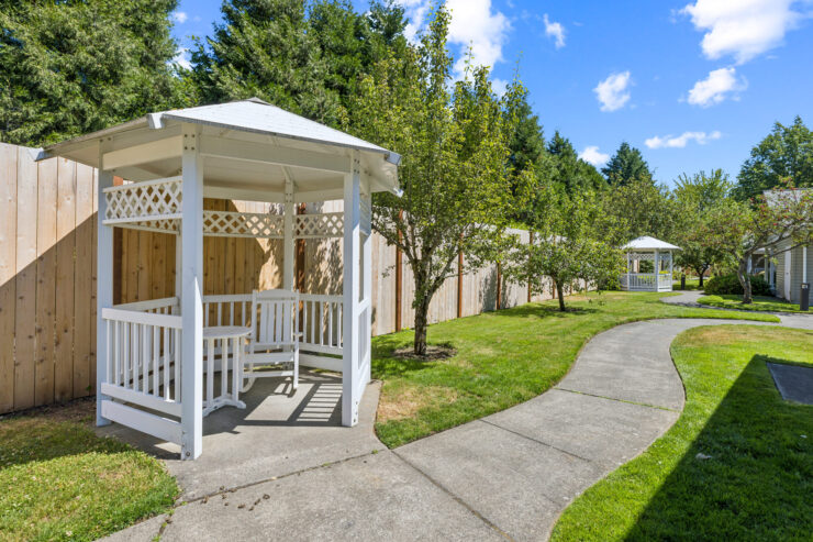 A serene garden pathway leads to inviting gazebos, perfect for relaxation and community gatherings.