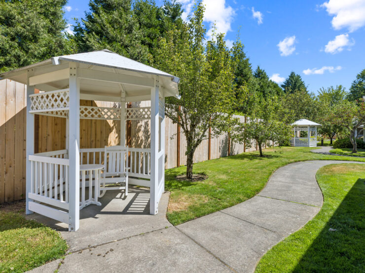 A serene garden pathway leads to inviting gazebos, perfect for relaxation and community gatherings.