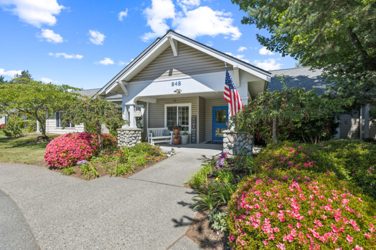 Welcoming entrance surrounded by vibrant flowers, inviting residents to a warm community atmosphere.