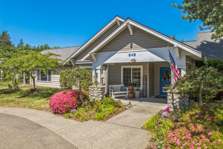 A welcoming entrance surrounded by vibrant flowers, inviting residents to enjoy community and comfort.