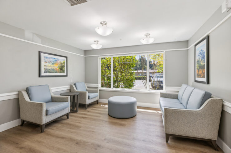 A bright, inviting lounge with comfortable seating and large windows, fostering community and warmth.