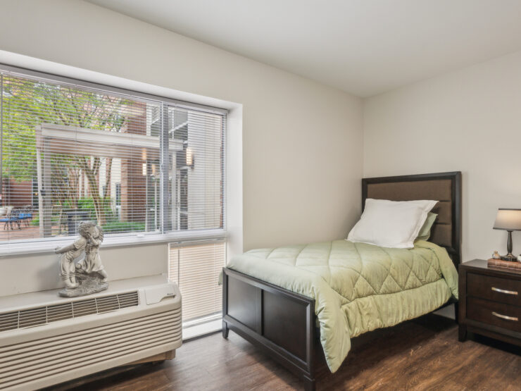 Bright and inviting, this room features a comfortable bed and a view of the serene garden, promoting relaxation and community.