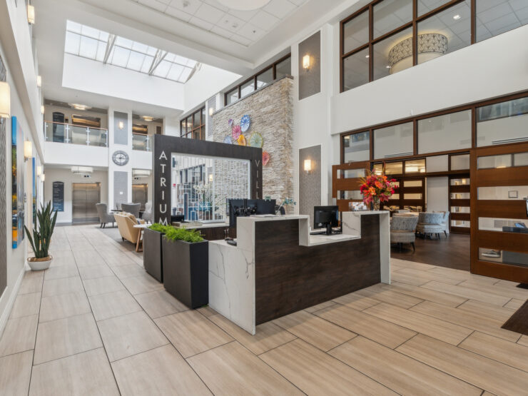 A welcoming atrium features bright spaces, vibrant decor, and friendly seating, fostering community and comfort.