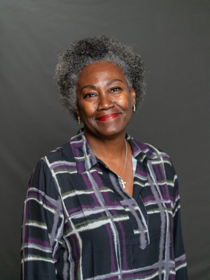 A warm smile radiates from a woman, embodying the spirit of community and connection.