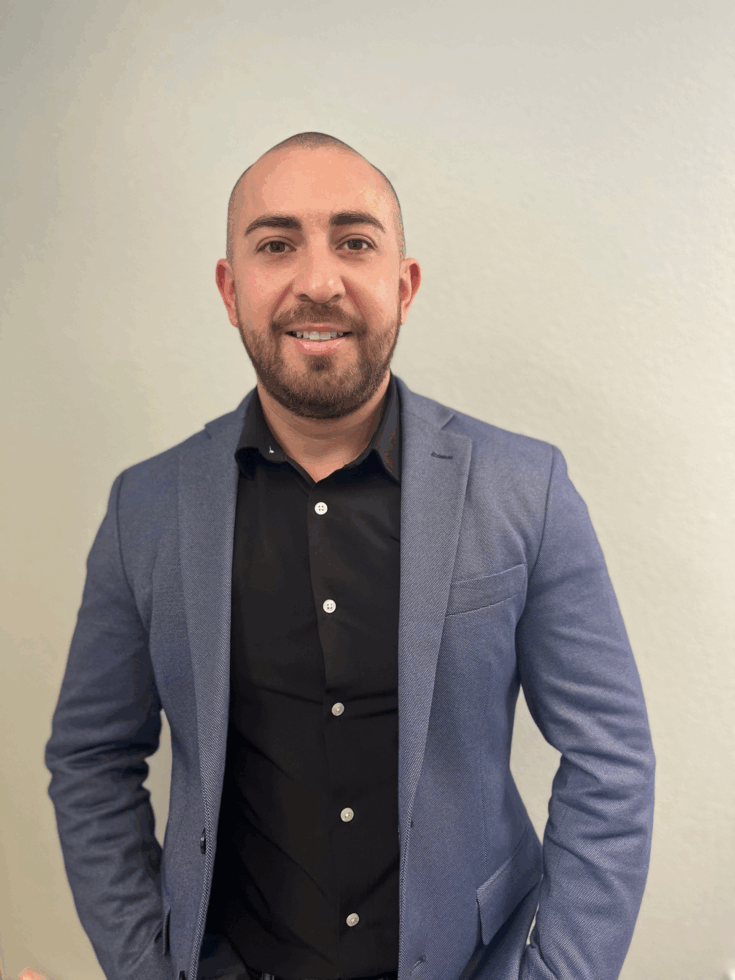 A friendly professional in a tailored suit, radiating warmth and approachability, invites community connection.