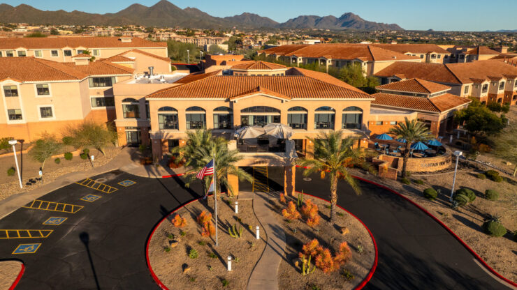 A welcoming entrance surrounded by vibrant landscaping and scenic mountains, inviting community and comfort.