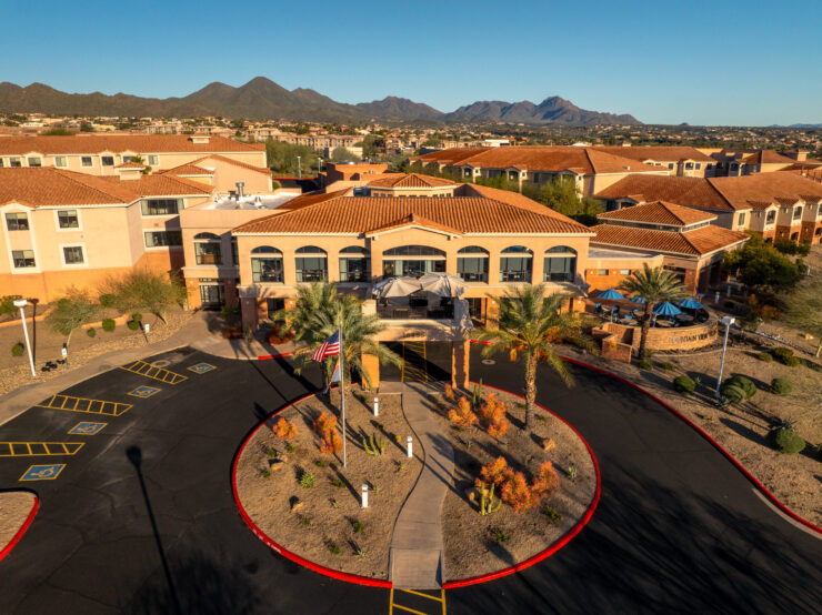 A welcoming entrance surrounded by vibrant landscaping and scenic mountains, inviting community and comfort.
