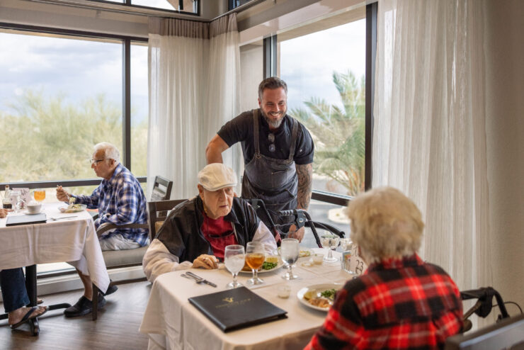 Residents enjoy a warm meal together, sharing laughter and companionship in a bright, welcoming dining space.