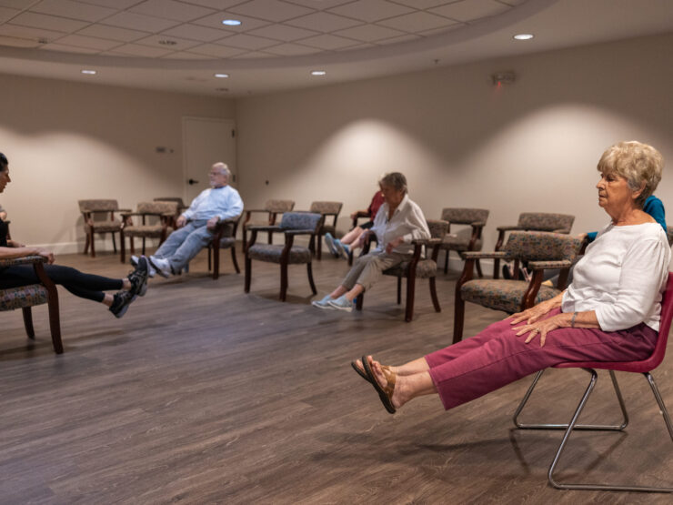 Residents engage in a seated activity, fostering community and connection in a warm, inviting space.
