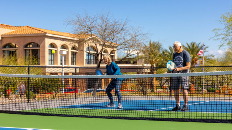 Active seniors enjoy a sunny day on the pickleball court, promoting community and joy in their lives.