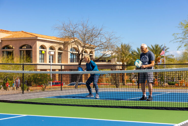 Active seniors enjoy a sunny day on the pickleball court, promoting community and joy in their lives.