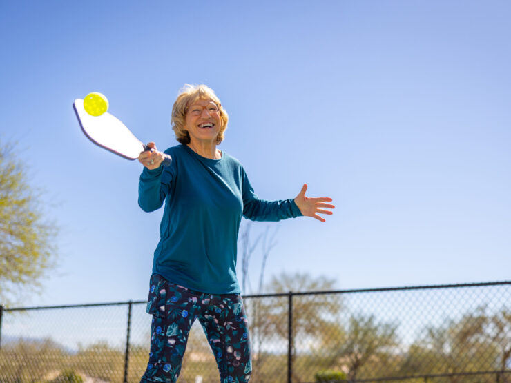An active resident enjoys a game outdoors, radiating joy and community spirit under a clear blue sky.