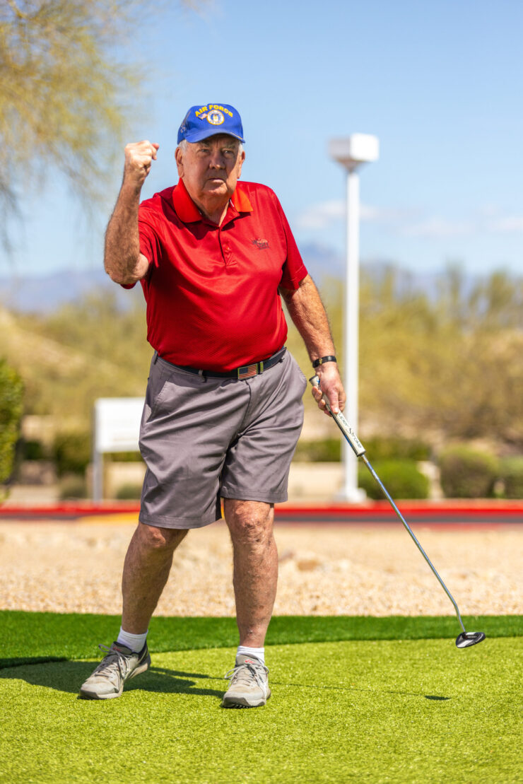 A spirited senior golfer celebrates a successful shot, embodying joy and community in a vibrant outdoor setting.