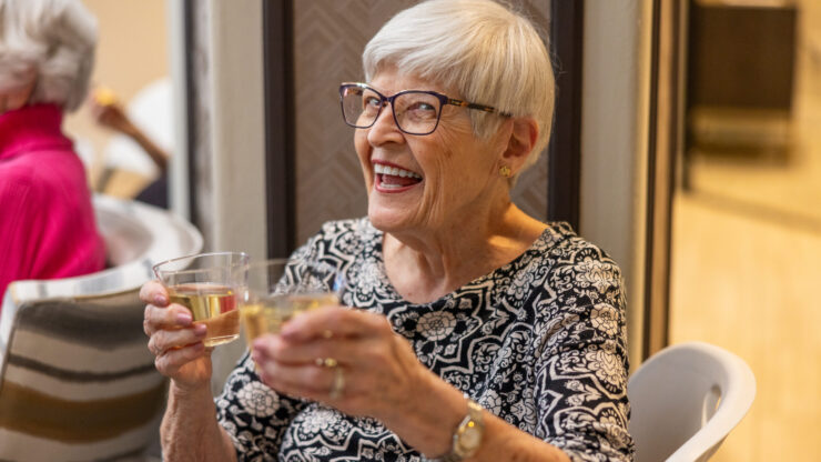 Joyful residents share a delightful moment, raising glasses in celebration within a warm, inviting space.