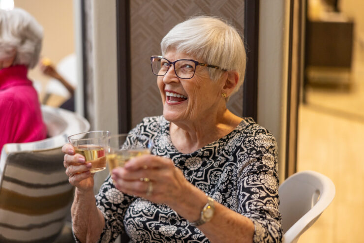 Joyful residents share a delightful moment, raising glasses in celebration within a warm, inviting space.