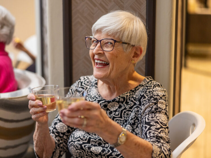 Joyful residents share a delightful moment, raising glasses in celebration within a warm, inviting space.